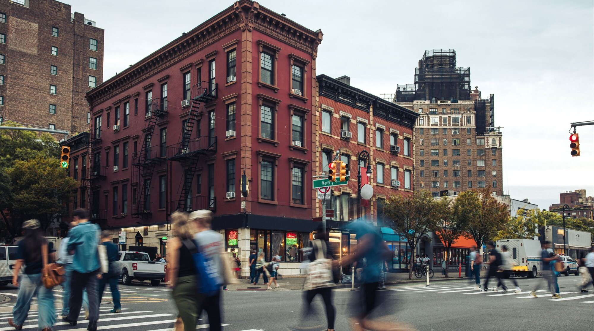 Cruzamento movimentado com a rua Waverly Place em Nova York. Saiba o que mais fazer em Nova York, para ter uma viagem fora do roteiro tradiiconal.