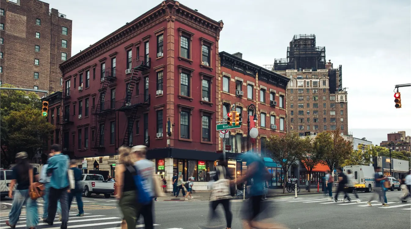 Cruzamento movimentado com a rua Waverly Place em Nova York. Saiba o que mais fazer em Nova York, para ter uma viagem fora do roteiro tradiiconal.