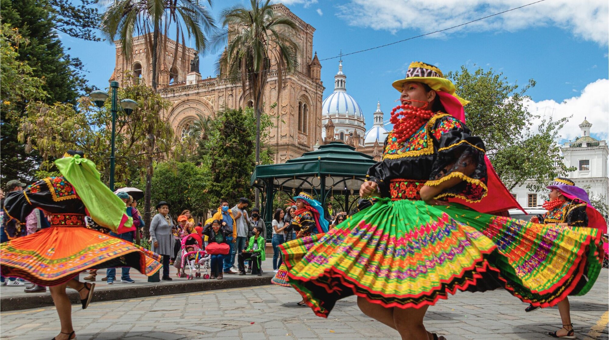 Un grupo de bailarines folclóricos de Cayambe en Cuenca, Ecuador, vestidos con trajes tradicionales.