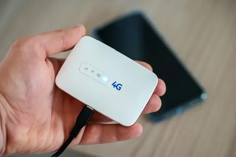 Dispositivo de Pocket Wi-Fi portátil sostenido en la mano con conexión activa