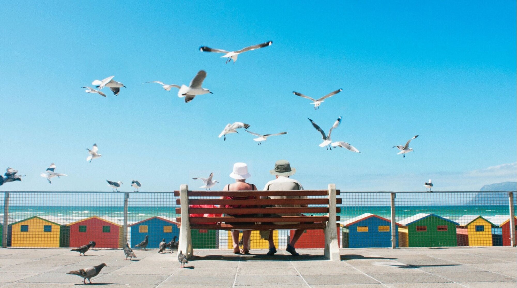 Um casal de idosos aproveita o almoço na Praia de Muizenberg, na Cidade do Cabo.