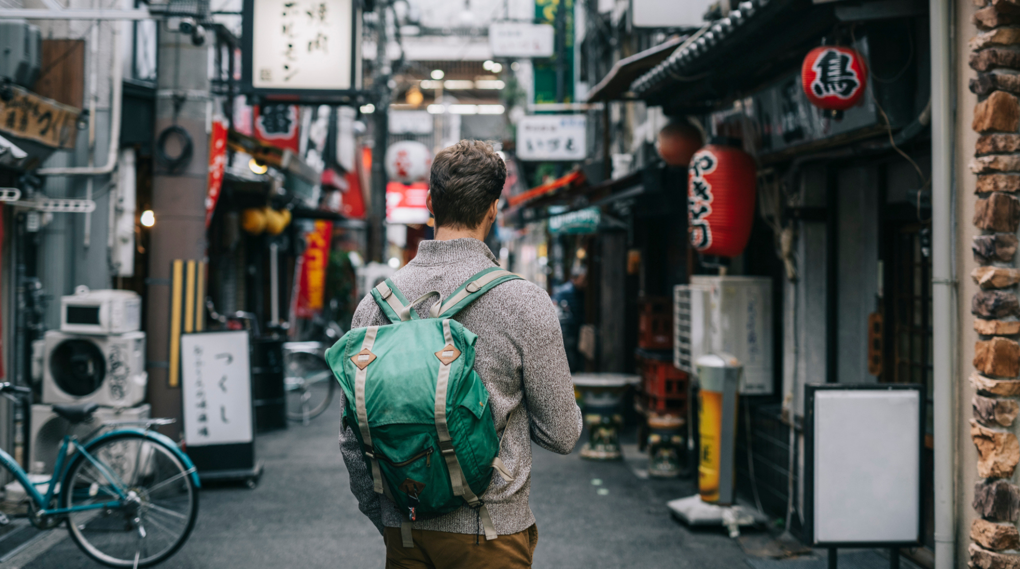 Viaggiatore che usa lo smartphone in una strada urbana del Giappone per orientarsi e restare connesso durante il viaggio