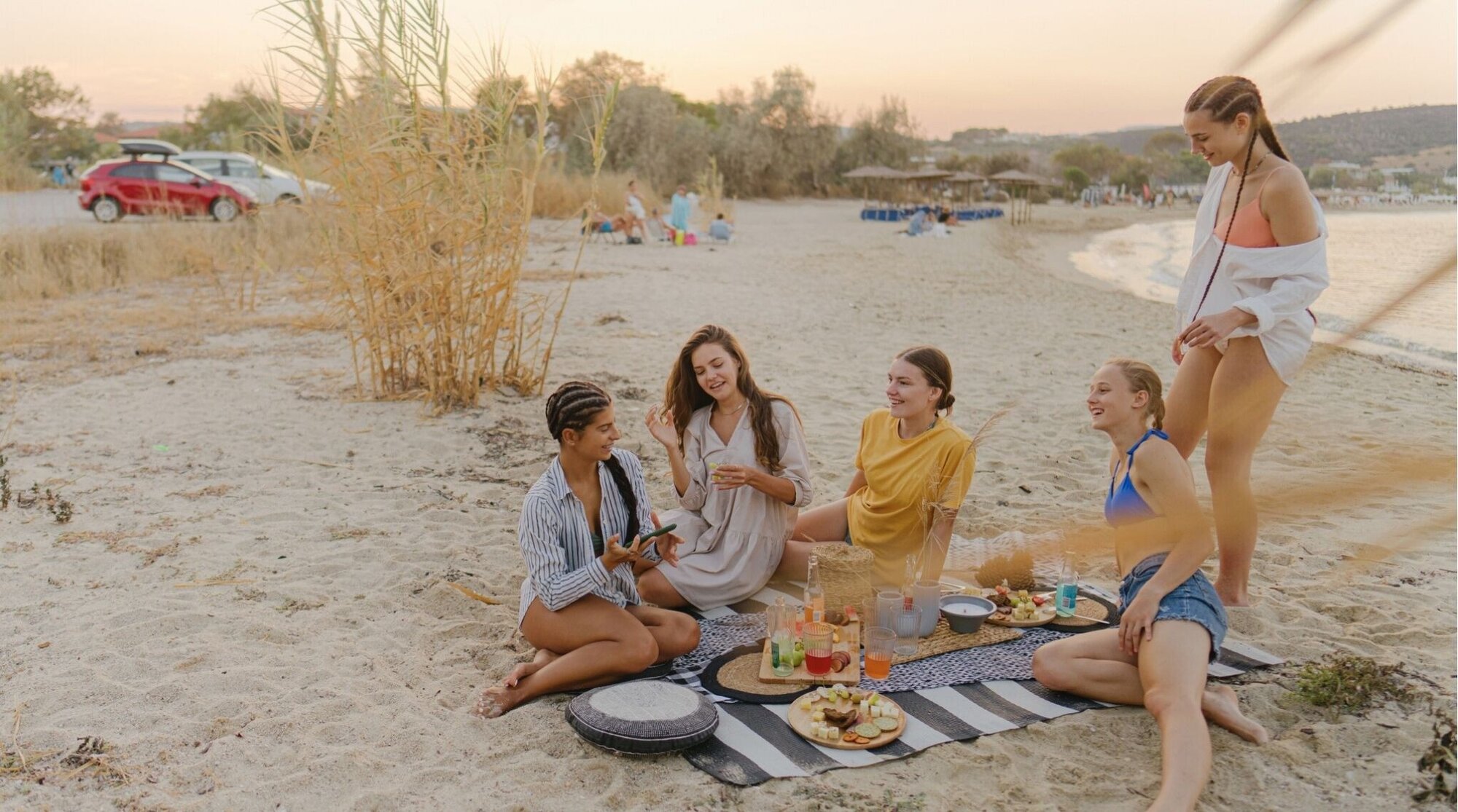 Amigas haciendo picnic en la playa, plan relajado en vacaciones de primavera