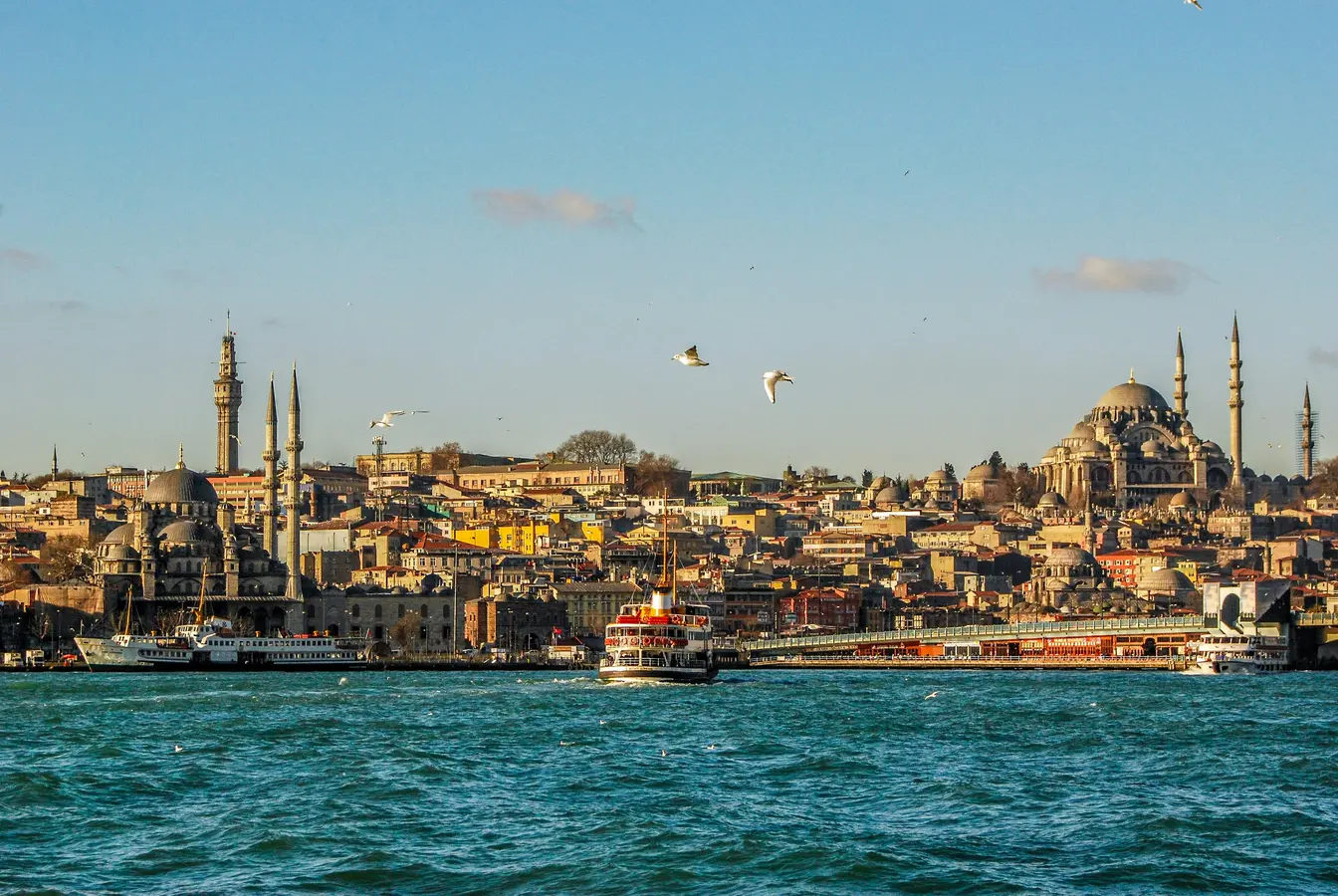 Imagen de la línea costera de Estambul desde el agua, mostrando el estrecho del Bósforo, la Mezquita Nueva y la Mezquita de Solimán al fondo.