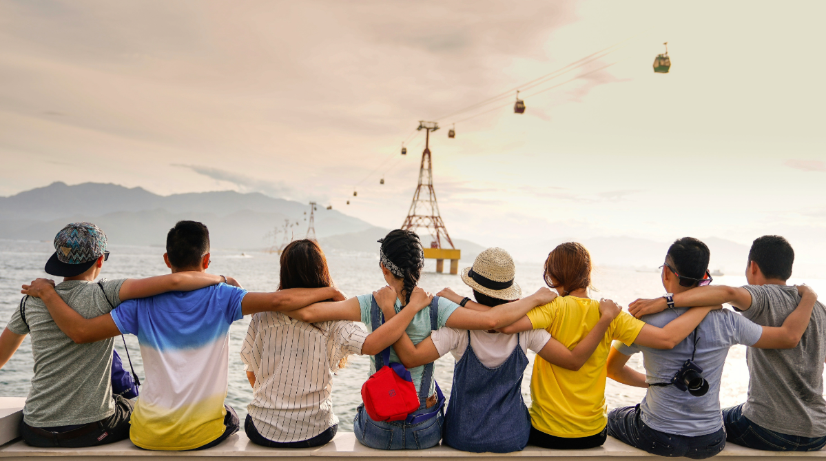 Friends sitting with arms around one another