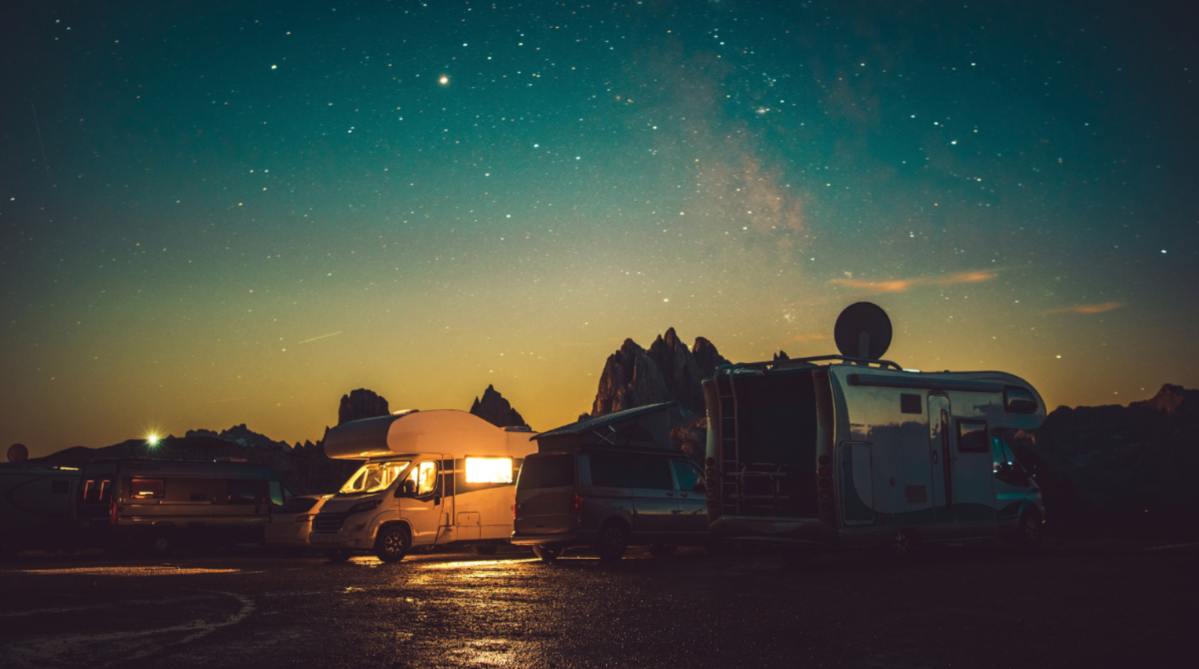 Two campervans with a satellite installed under the night sky