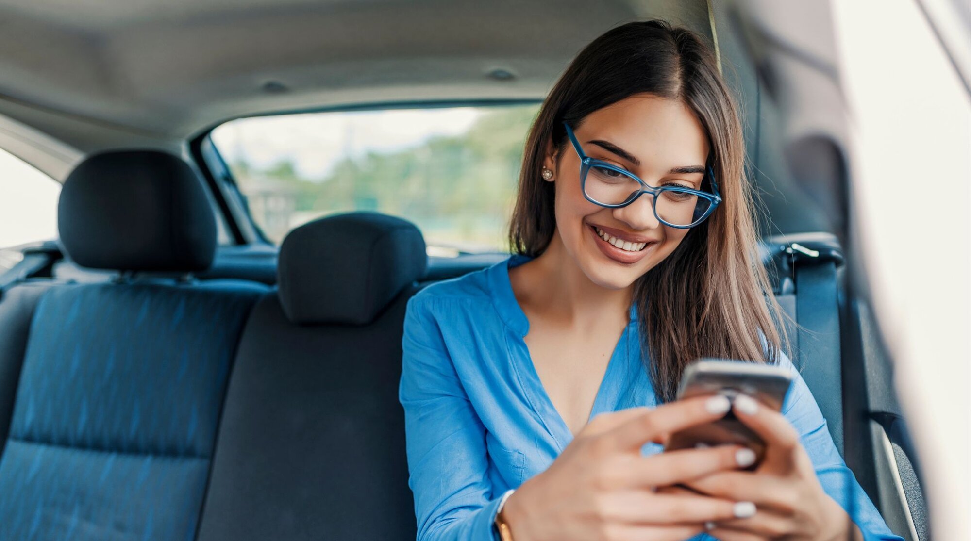 Voyageuse souriante qui utilise son téléphone pendant un voyage à l’étranger