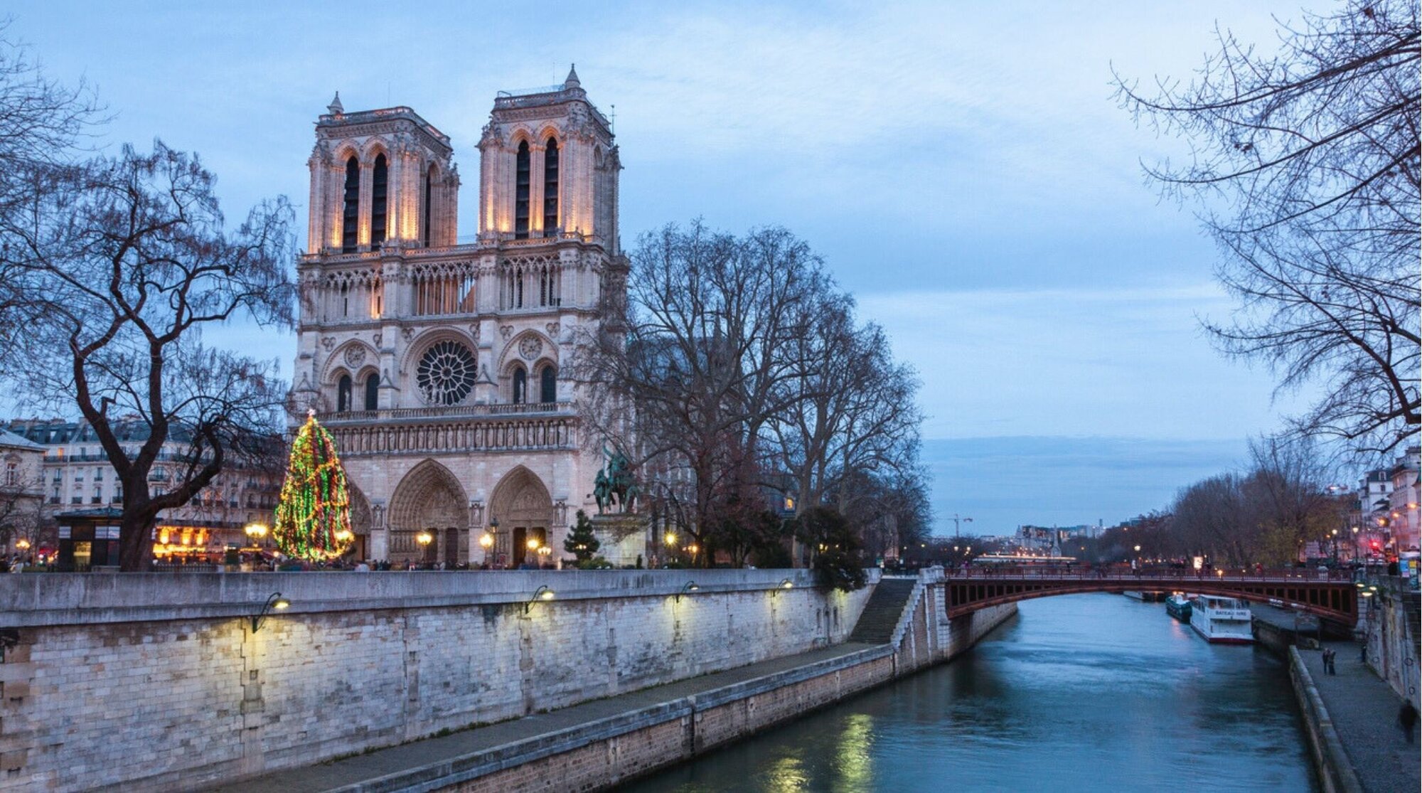 Catedral de Notre Dame iluminada por el atardecer durante el invierno en París con cielo rosado y clima frío.