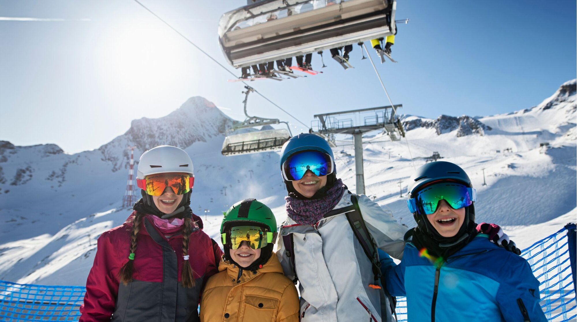  Familia con cascos y gafas de esquí en una estación, junto a un remonte; día soleado en las montañas de Andorra.]