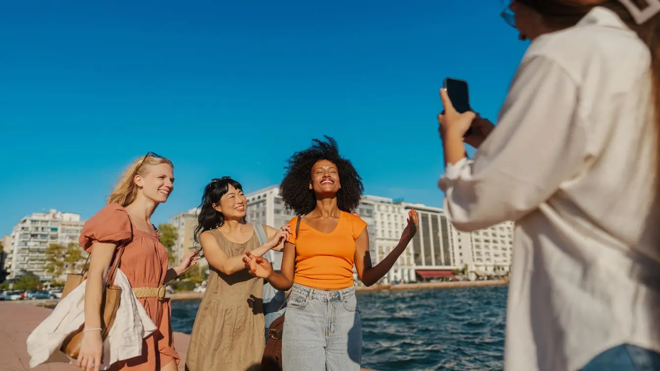 Eine Frauengruppe benutzt eine eSIM für Europa, um Selfies zu teilen.