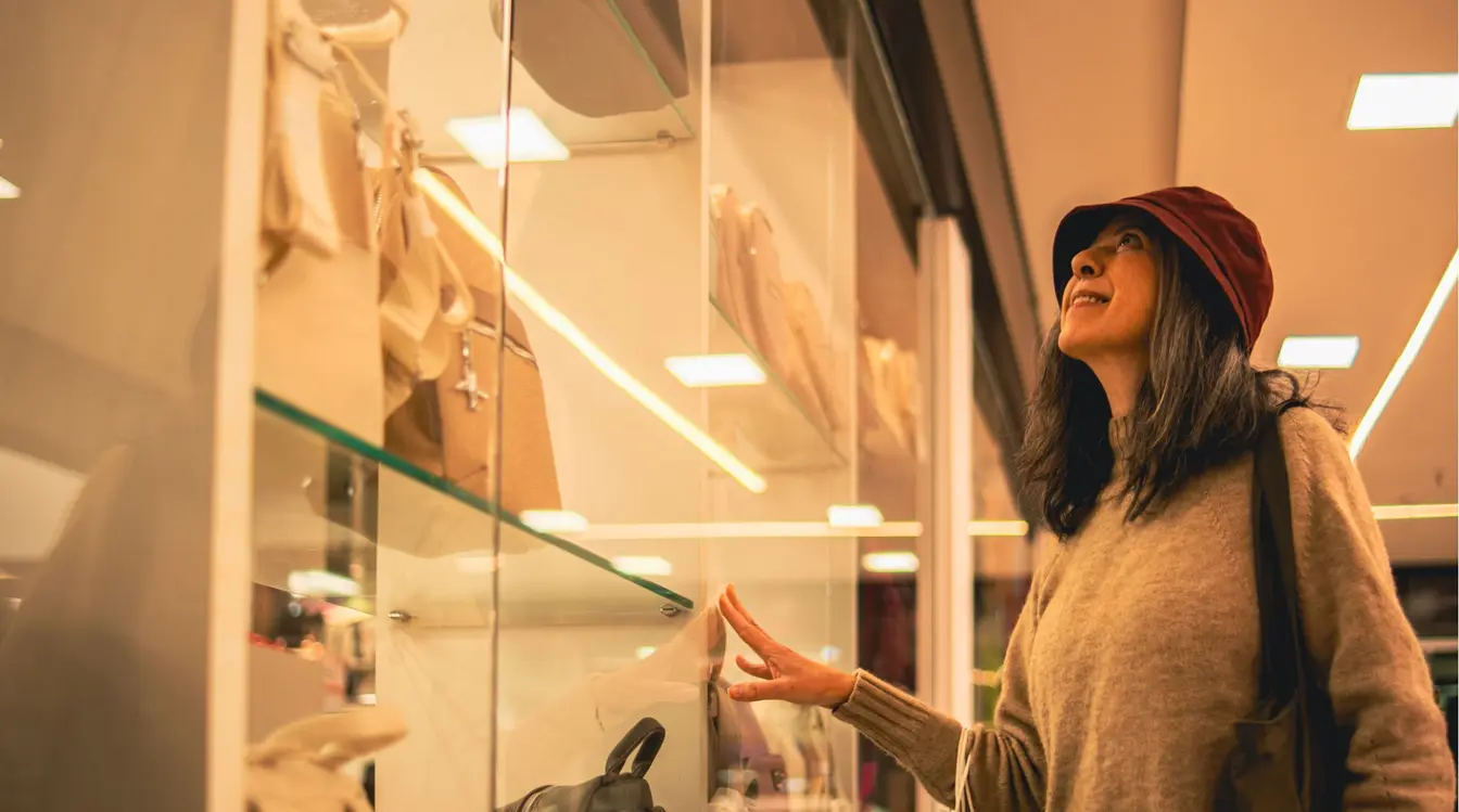Turista observando vitrines de bolsas em grande loja de roupas e acessórios no Paraguai.