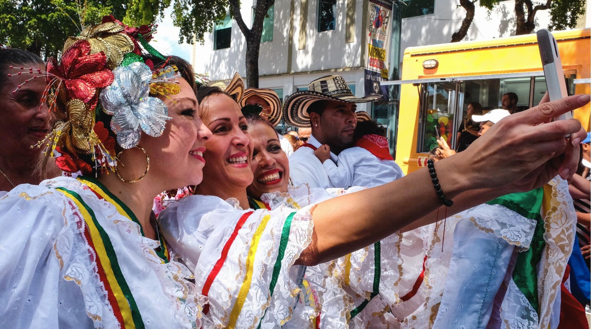 Grupo de mulheres carnavalescas de todas as idades tirando uma selfie com seus smartphones no Festival Calle Ocho de Little Havana, em Miami, em 2014.