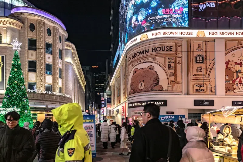 イルミネーションが輝く冬のソウル・明洞の夜景。クリスマスツリーと多くの観光客で賑わうショッピングストリートの様子。