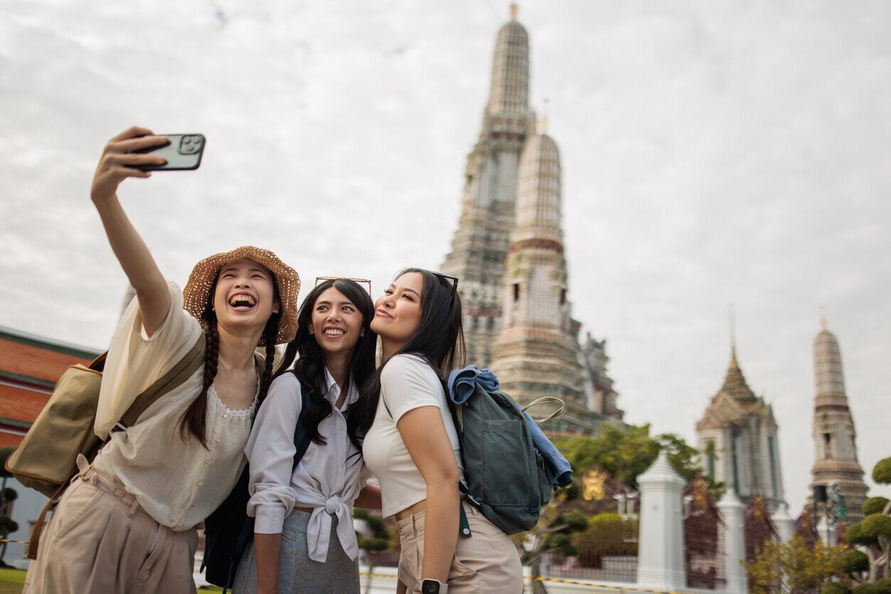 Frauen mit Internet in Thailand vor einem Tempel