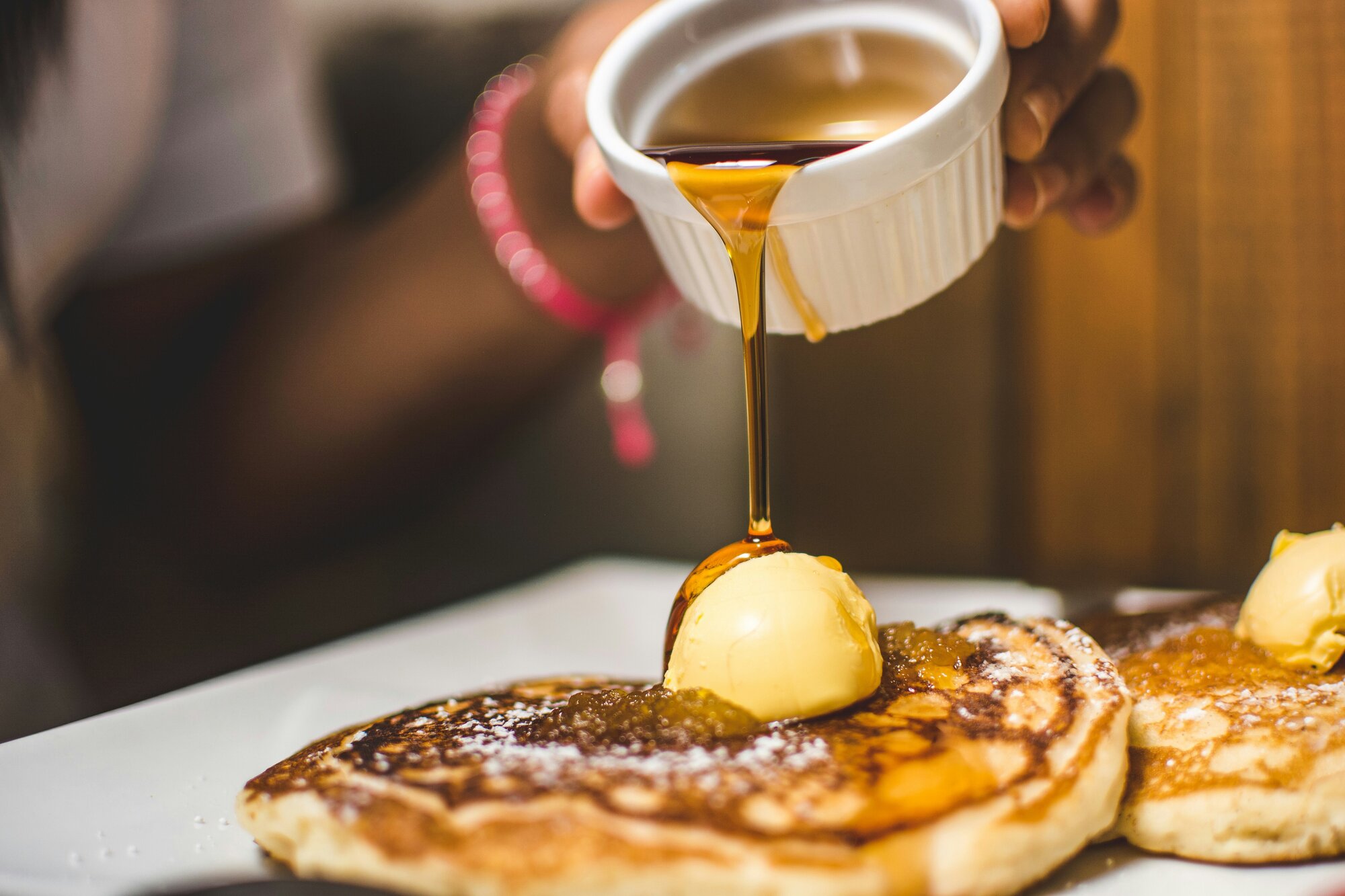 Maple syrup is put on pancakes