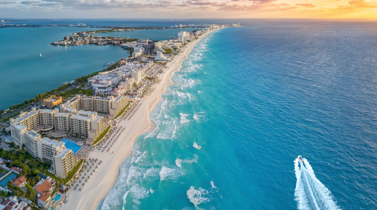 Large vacation resorts on a sandy beach with blue water, in Cancun, Mexico, a popular spring break party location.