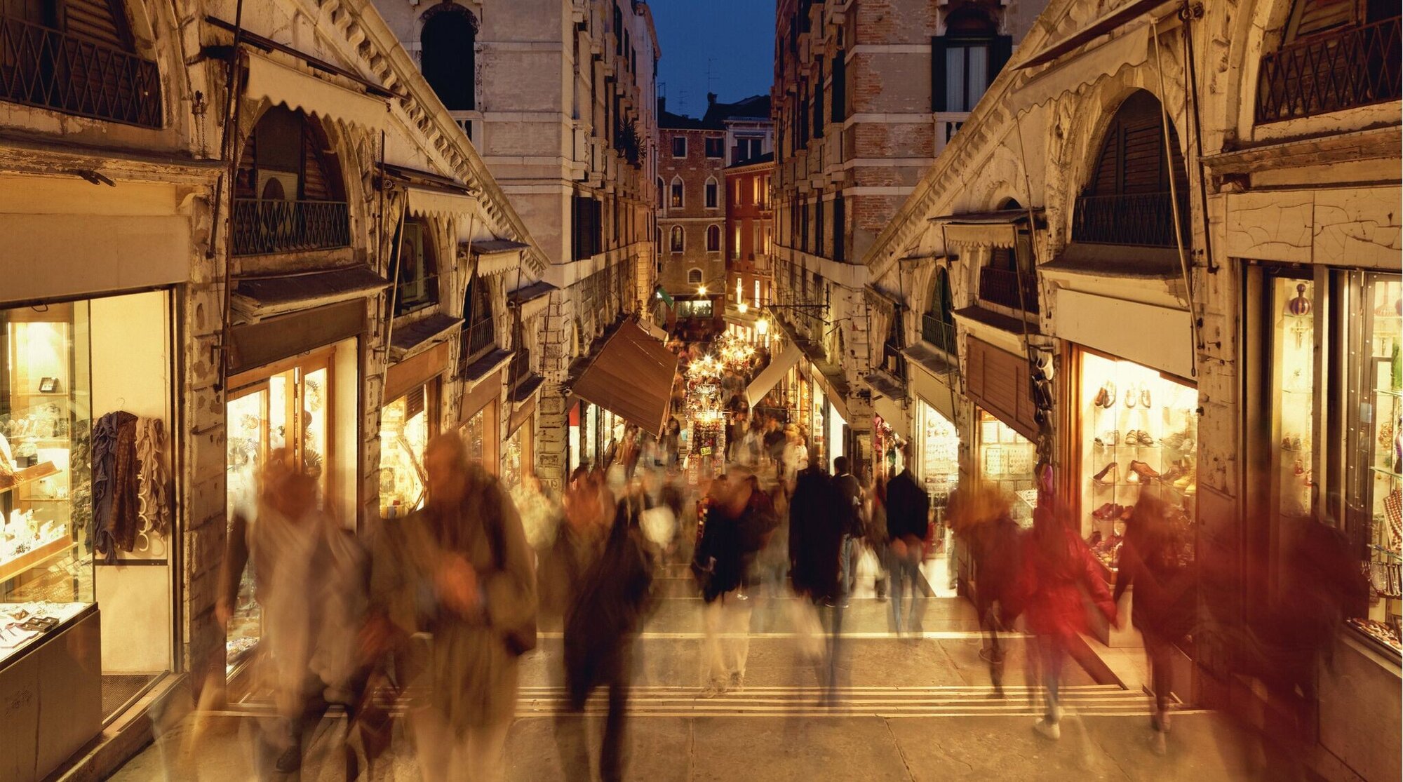 Pessoas irreconhecíveis (longa exposição, desfoque de movimento) na Ponte de Rialto em Veneza.