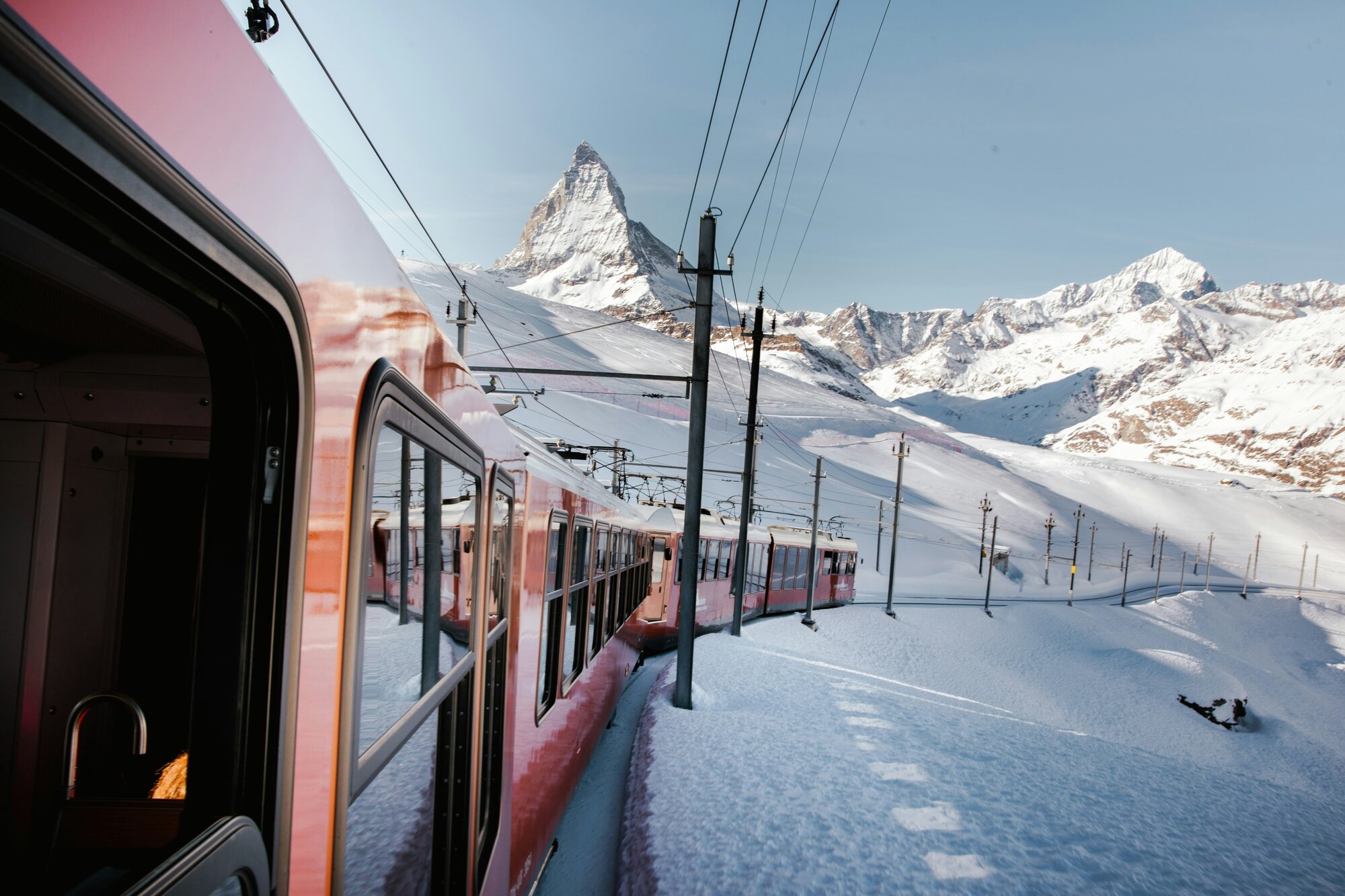 Red train on a mountain backdrop in Zermatt, Switzerland, one of the best ski trips in Europe