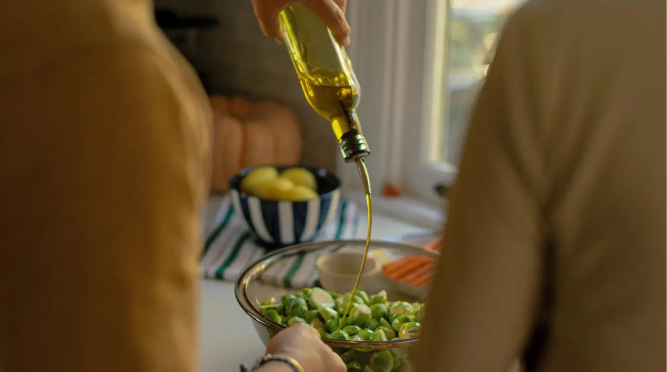 Duas pessoas temperando salada com azeite português.