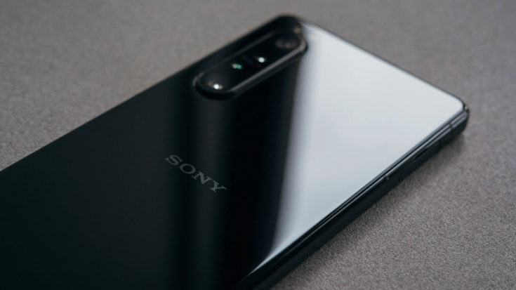 A colour photograph showing a close-up of a Sony Xperia Series Two phone model in back, against a brown table. you can only see the back of the phone, as it's lying face-down on the table. To illustrate a blog post entitled 'Does Sony Xperia Support eSIM Technology? .'