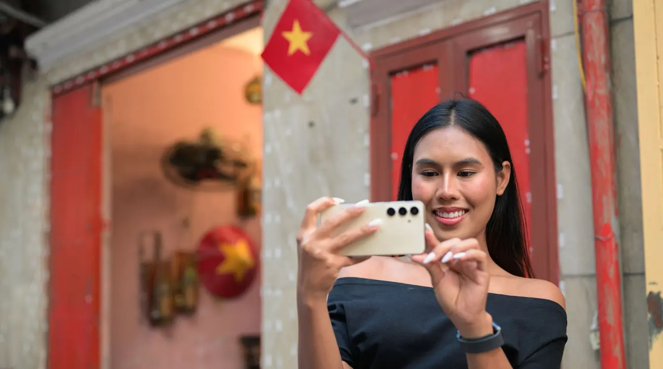 Eine junge Frau nutzt eine App in Vietnam, um sich auf der Straße zurechtzufinden