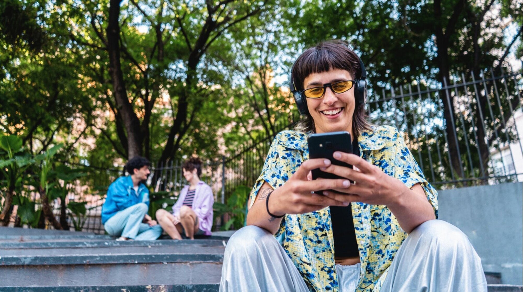 Persona joven usando el móvil al aire libre; dudas sobre eSIM gratis y promociones.
