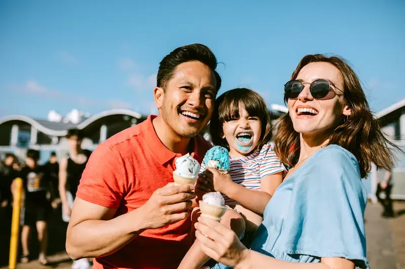 Familia comiendo helado en un muelle de California durante un día de viaje en Estados Unidos. 
