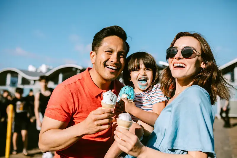 Familia comiendo helado en un muelle de California durante un día de viaje en Estados Unidos. 