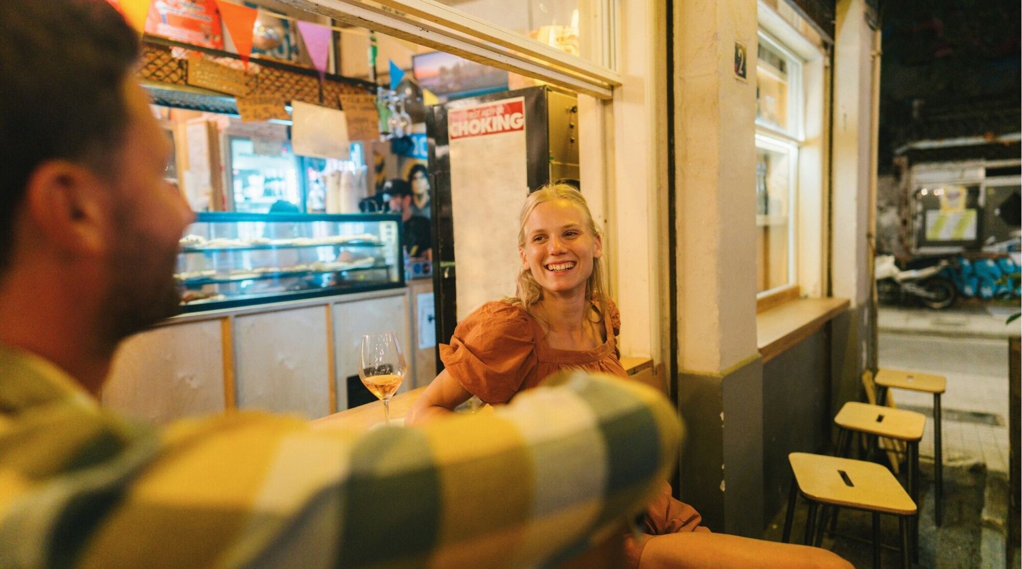 Foto de um casal que aprecia uma boa pizza e a companhia um do outro, em um encontro em uma pizzaria.