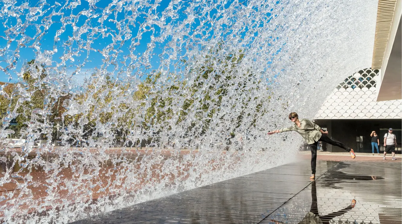 Viajante mulher se divertindo com as fontes no Parque das Nações, em Lisboa. 