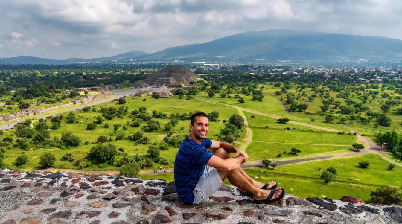 Viajero sentado en un mirador con vista panorámica de la zona arqueológica de Teotihuacán