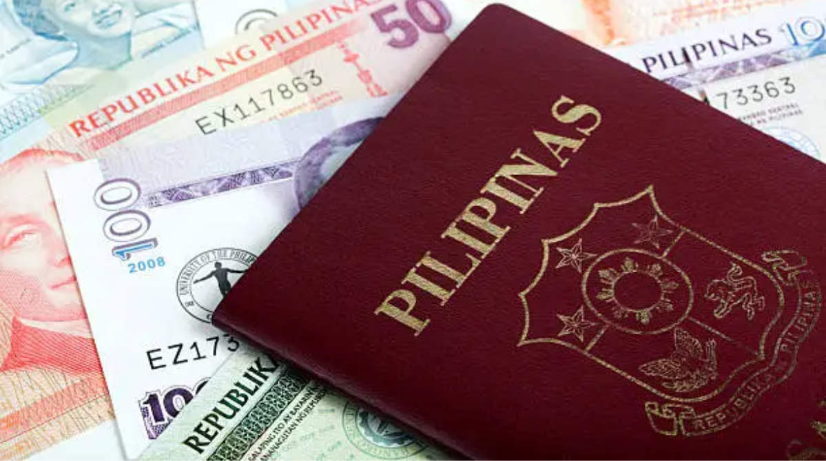 A Philippine passport on top of a stack of different international currencies