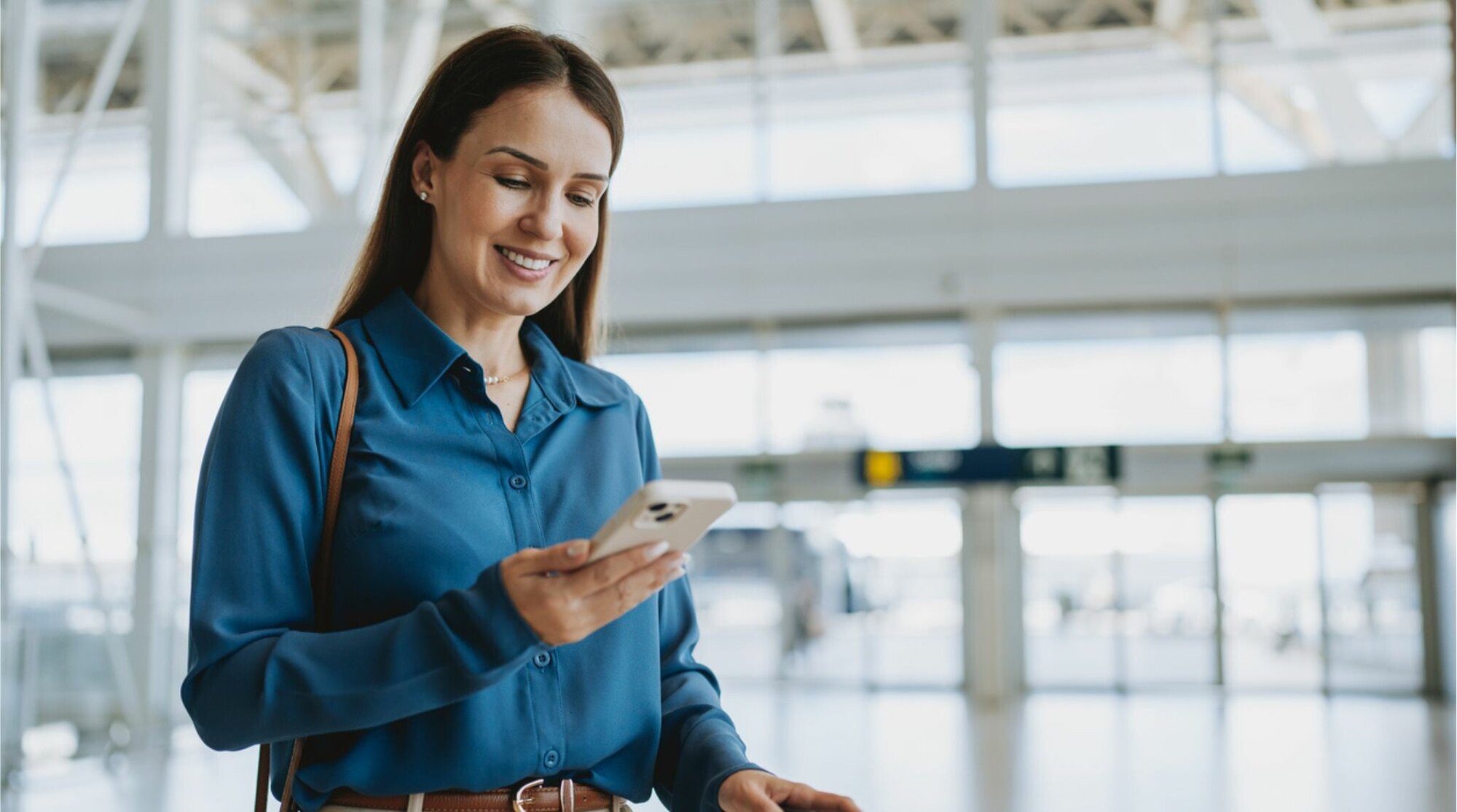 Mujer utilizando teléfono en aeropuerto
