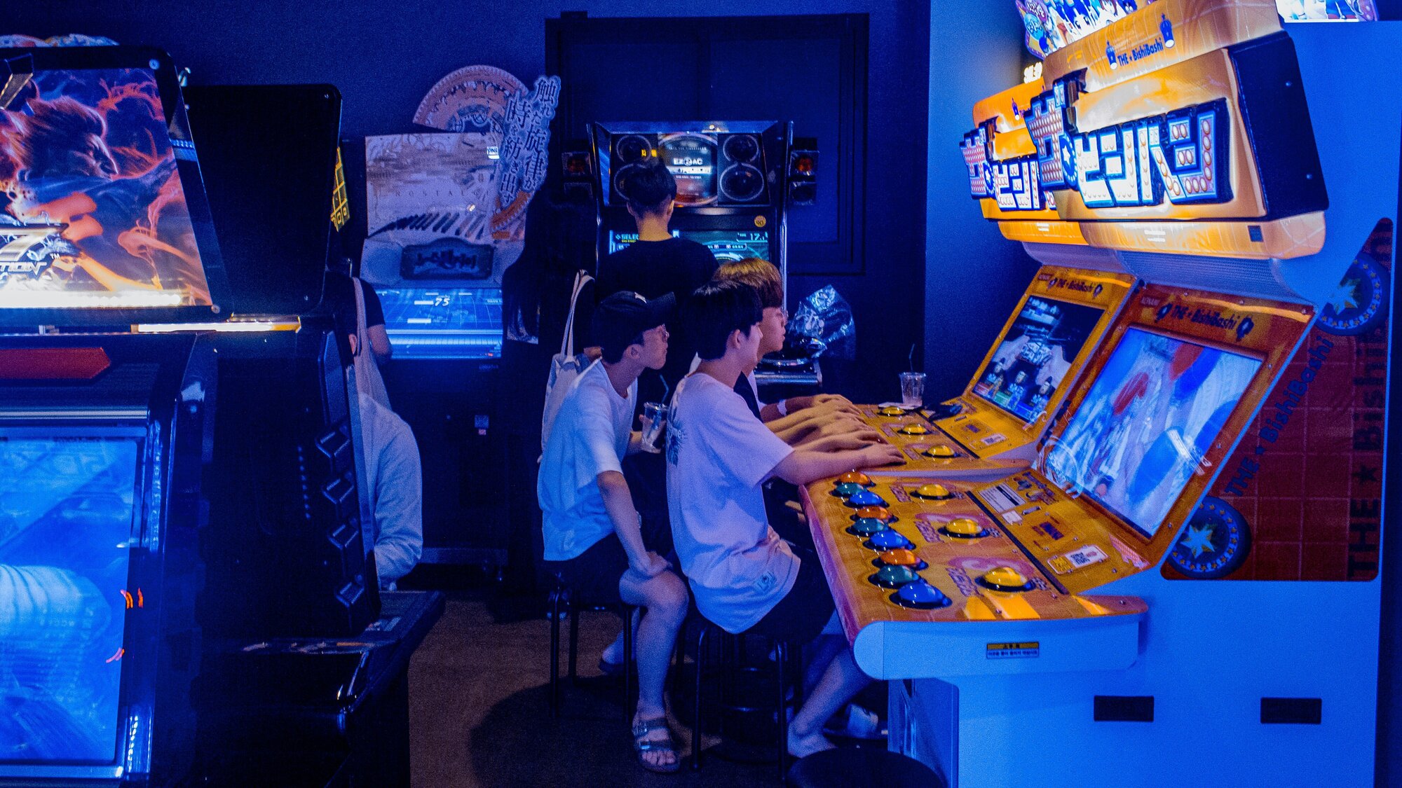 Young men gathered around an arcade game in Seoul, South Korea