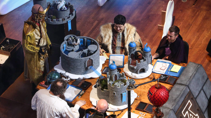An image of five men engaging in immersive tabletop role-playing at PAX West, one of the many creative experiences of this PAX event in Seattle, to show you can stay connected with a USA eSIM to share your adventure.