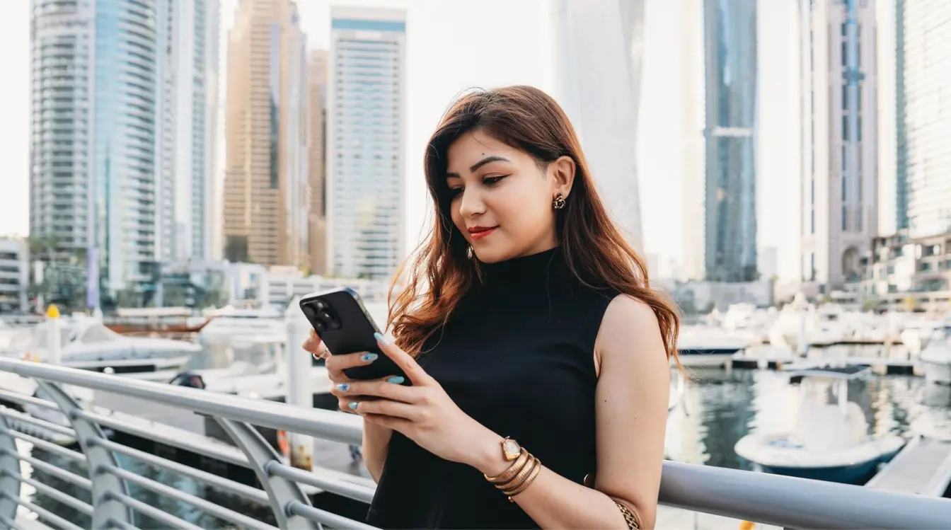 Jeune femme utilisant son smartphone dans la marina de Dubaï