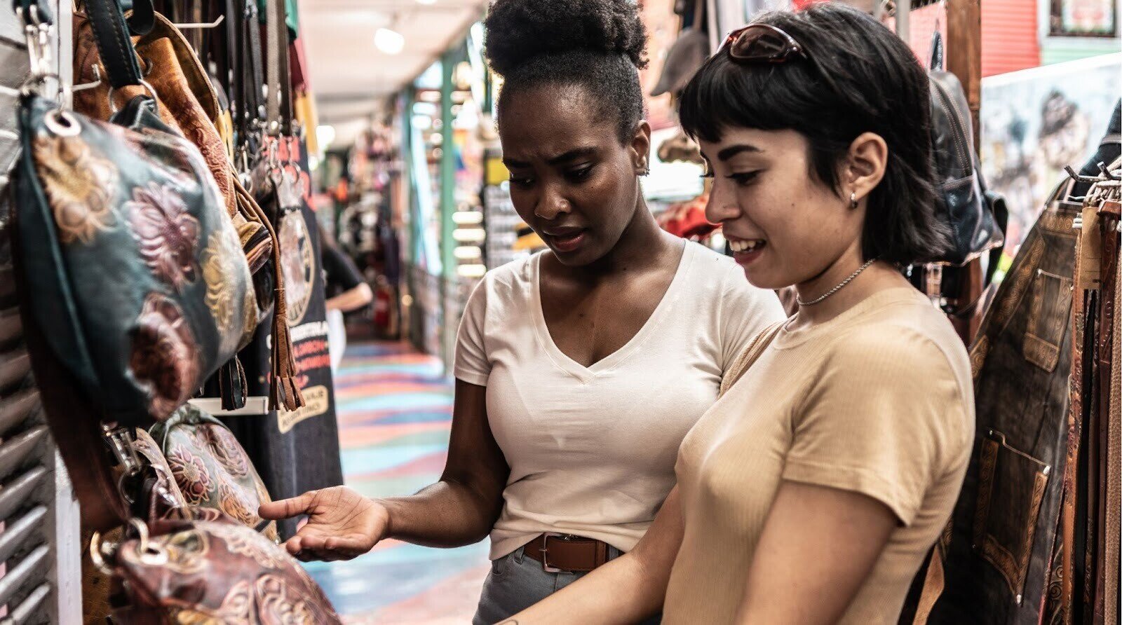 Amigas fazendo compras de artigos de couro em um mercado de rua na Argentina.