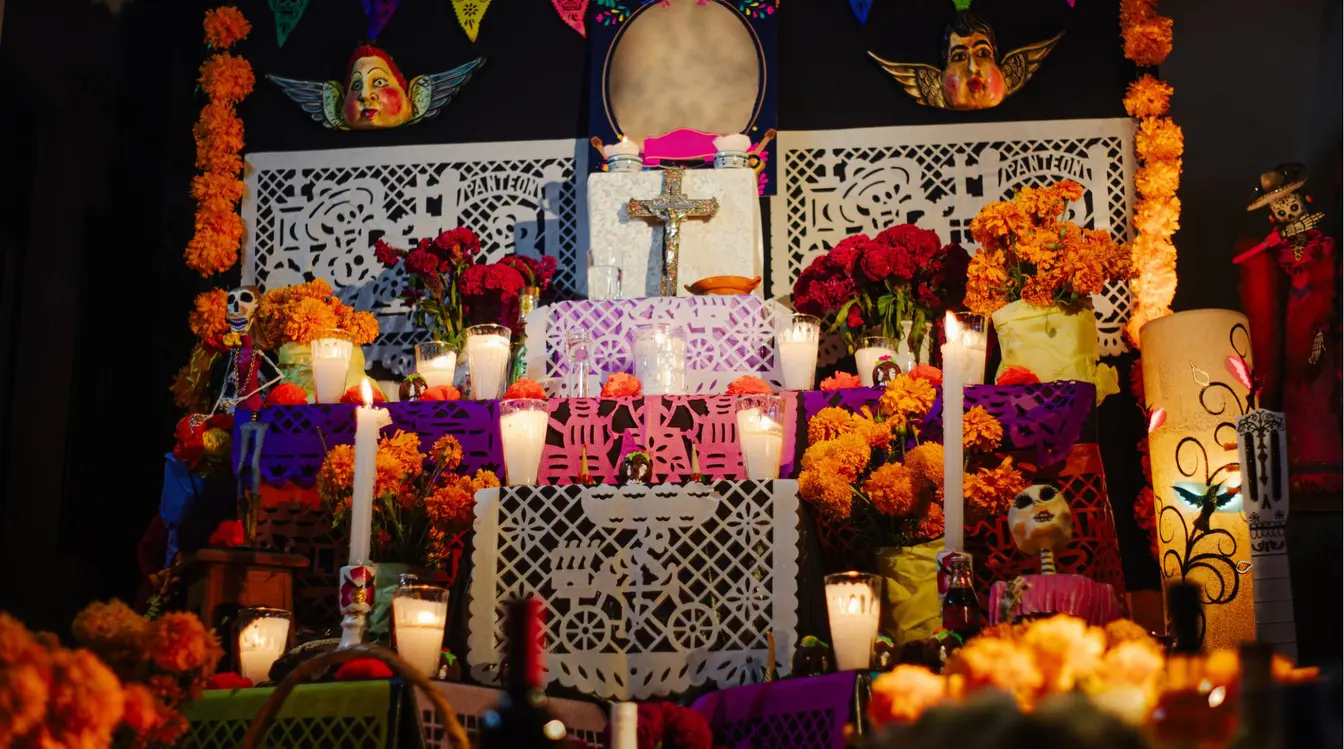 Autel traditionnel du Día de los Muertos au Mexique décoré de fleurs orange et de bougies.
