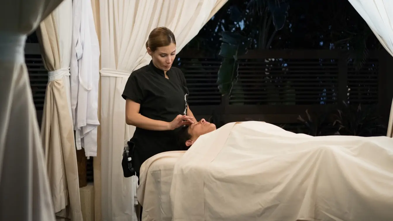 Mujer recibiendo un masaje profesional en una cabina de spa con vista al mar