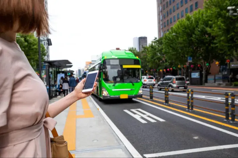 ソウル市内で路線バスをスマホ片手に待っている韓国人女性