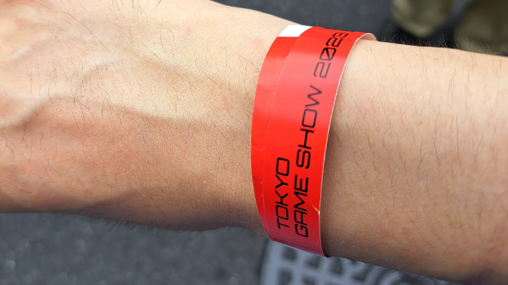 Close-up of a red wristband printed with Tokyo Game Show 2023, symbolising entry to the event — giving fans a glimpse of what to expect when securing Tokyo Game Show 2025 tickets.