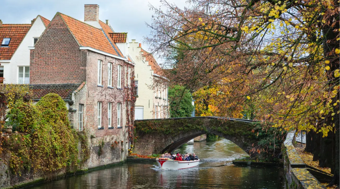 Turistas velejando pelos canais de Bruges durante o outono na Europa.