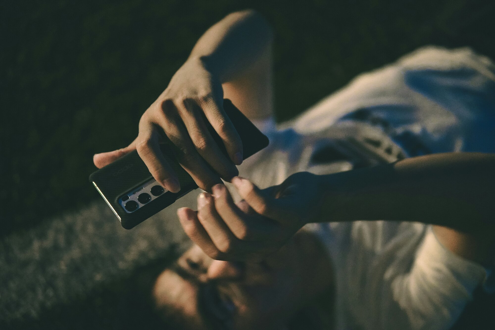 Man scrolling on his Oppo phone while lying down