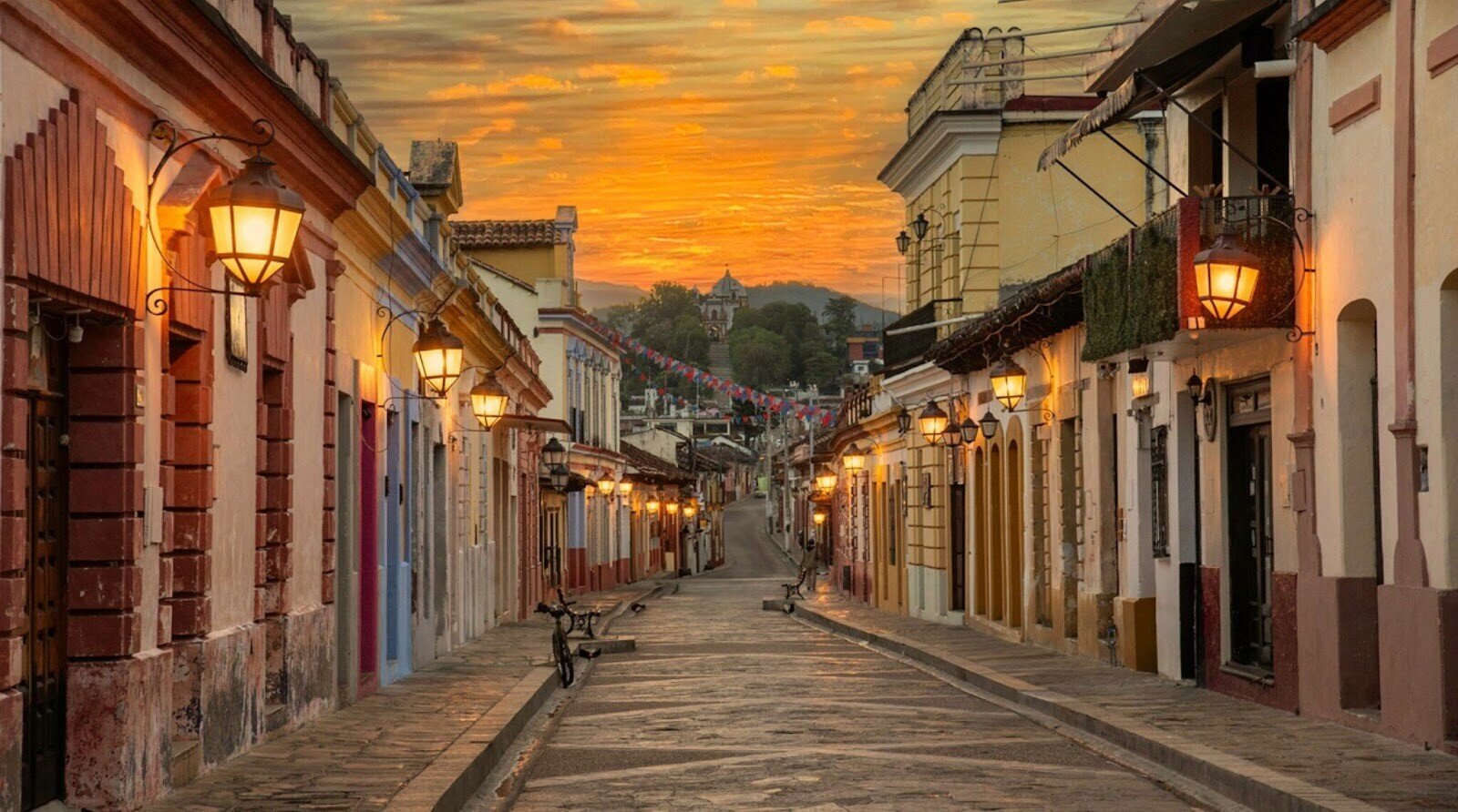 Rue de San Cristóbal de las Casas, plus belle ville du Chiapas, au coucher du soleil avec les lampadaires allumés et les façades colorées.