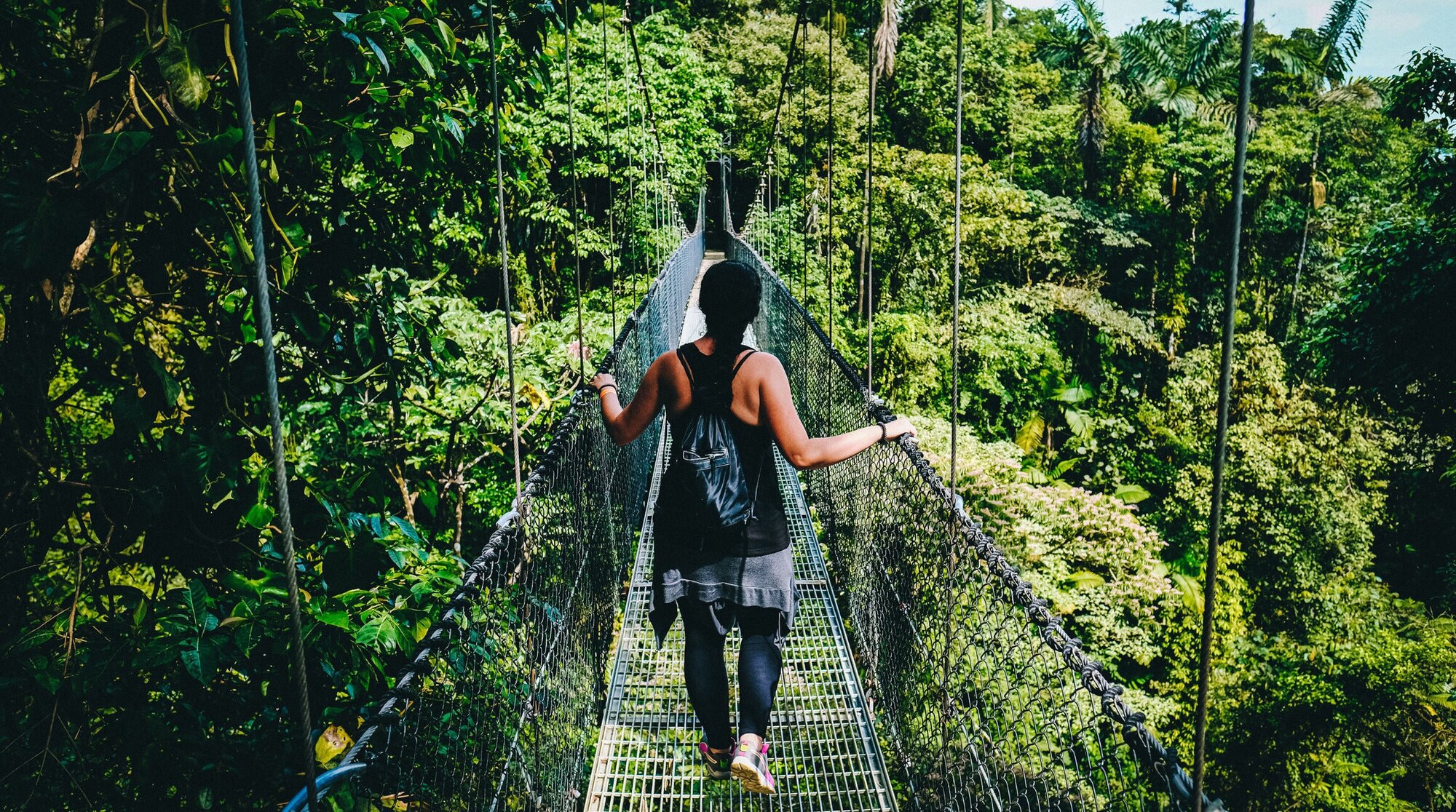 Woman walking on suspension bridge in Monteverde cloud forest