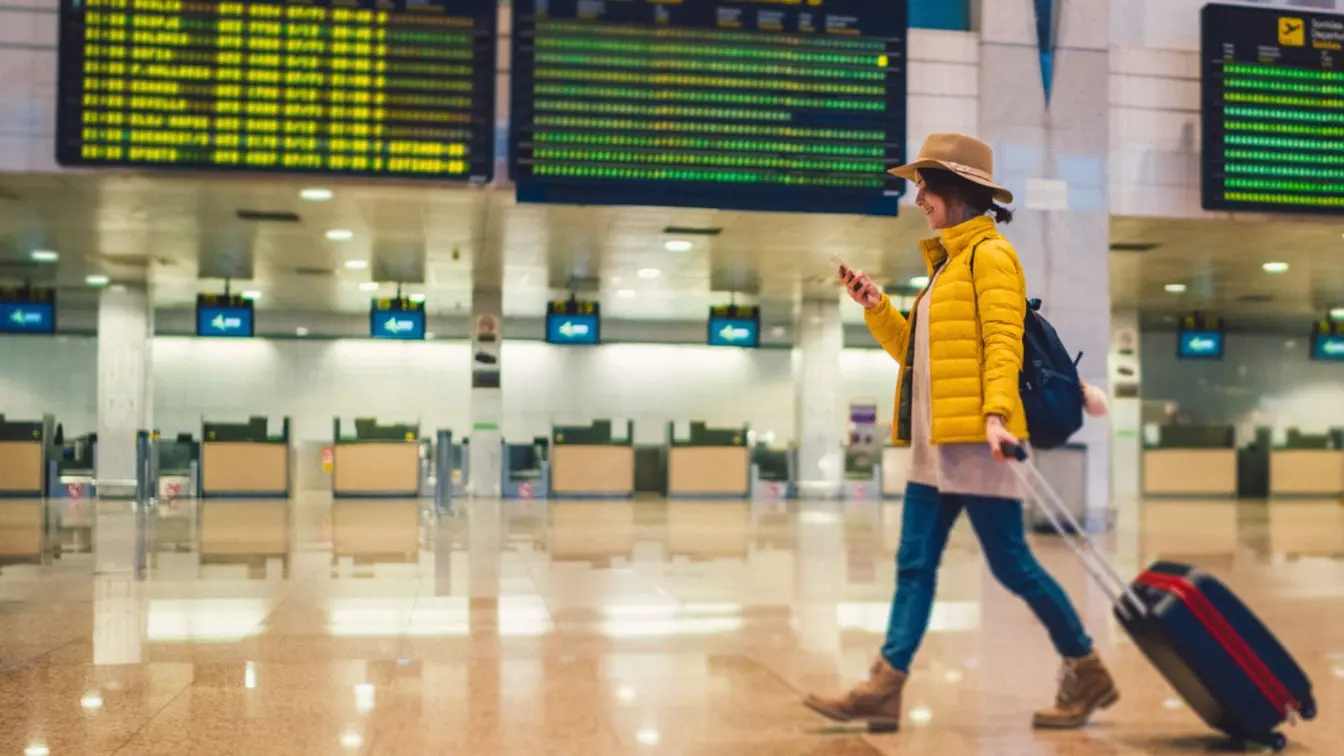 Voyageuse utilisant son smartphone dans un terminal d’aéroport