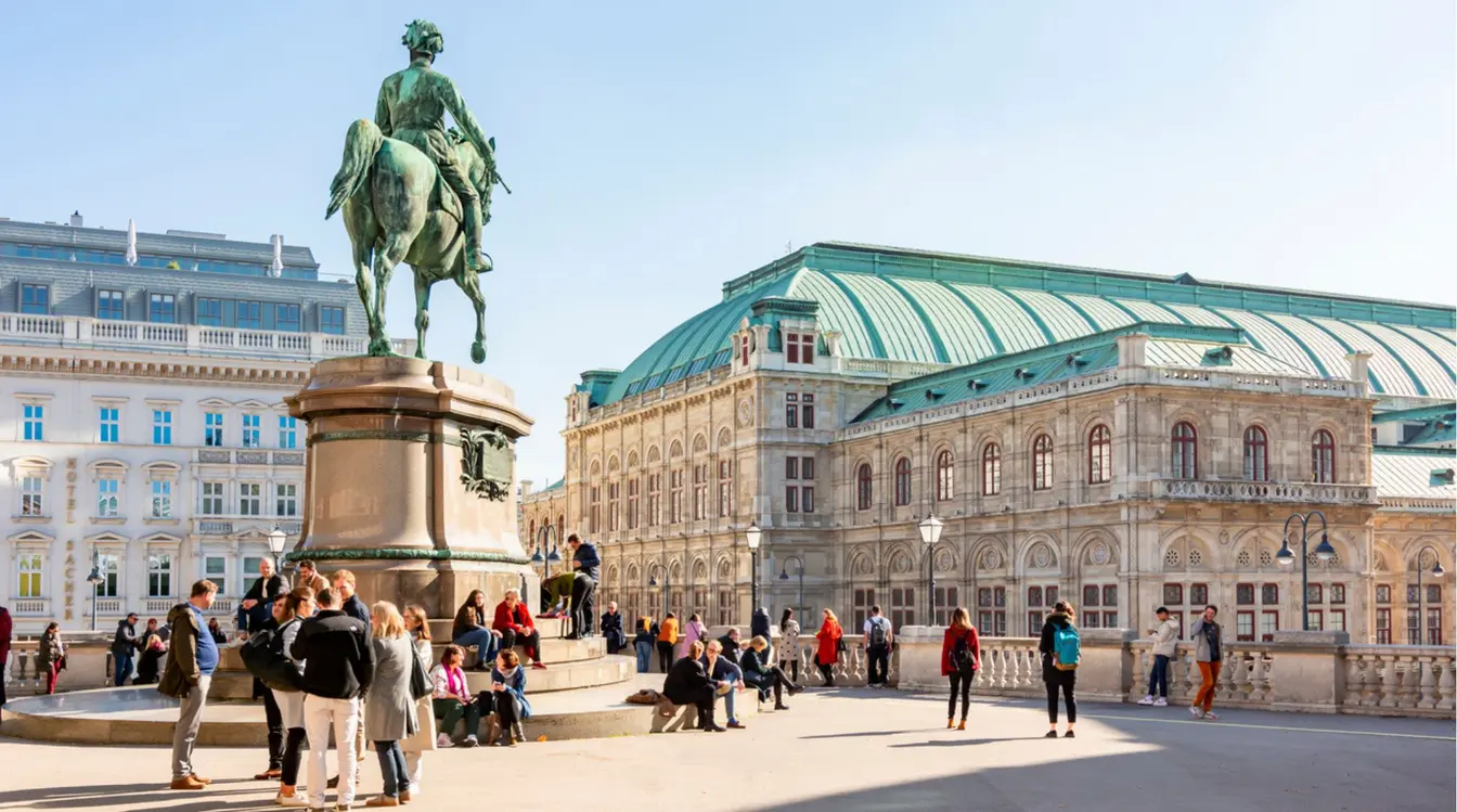 Turistas reunidos na Heldenplatz, a Praça dos Herois, em Viena, durante uma tarde ensolarada de outono.