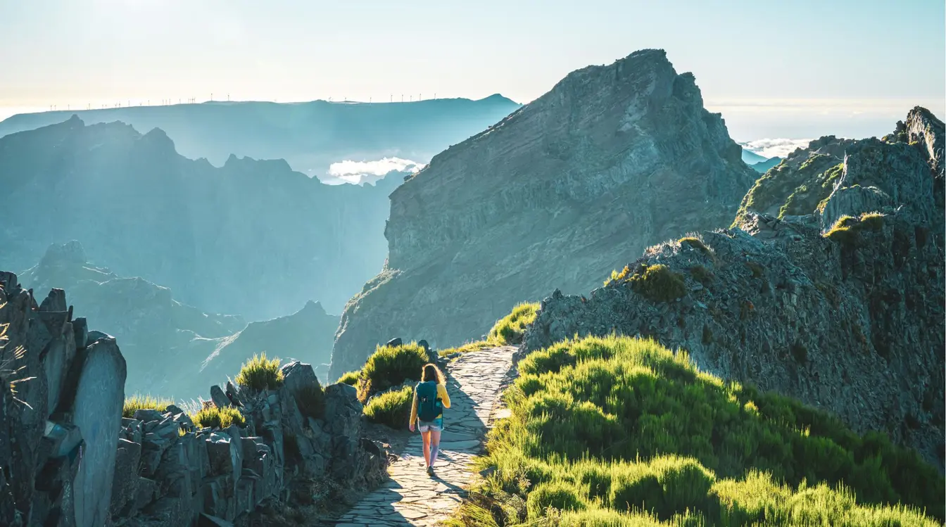 Randonneuse marchant sur un sentier de montagne à Madère, au cœur des paysages volcaniques de l'île.