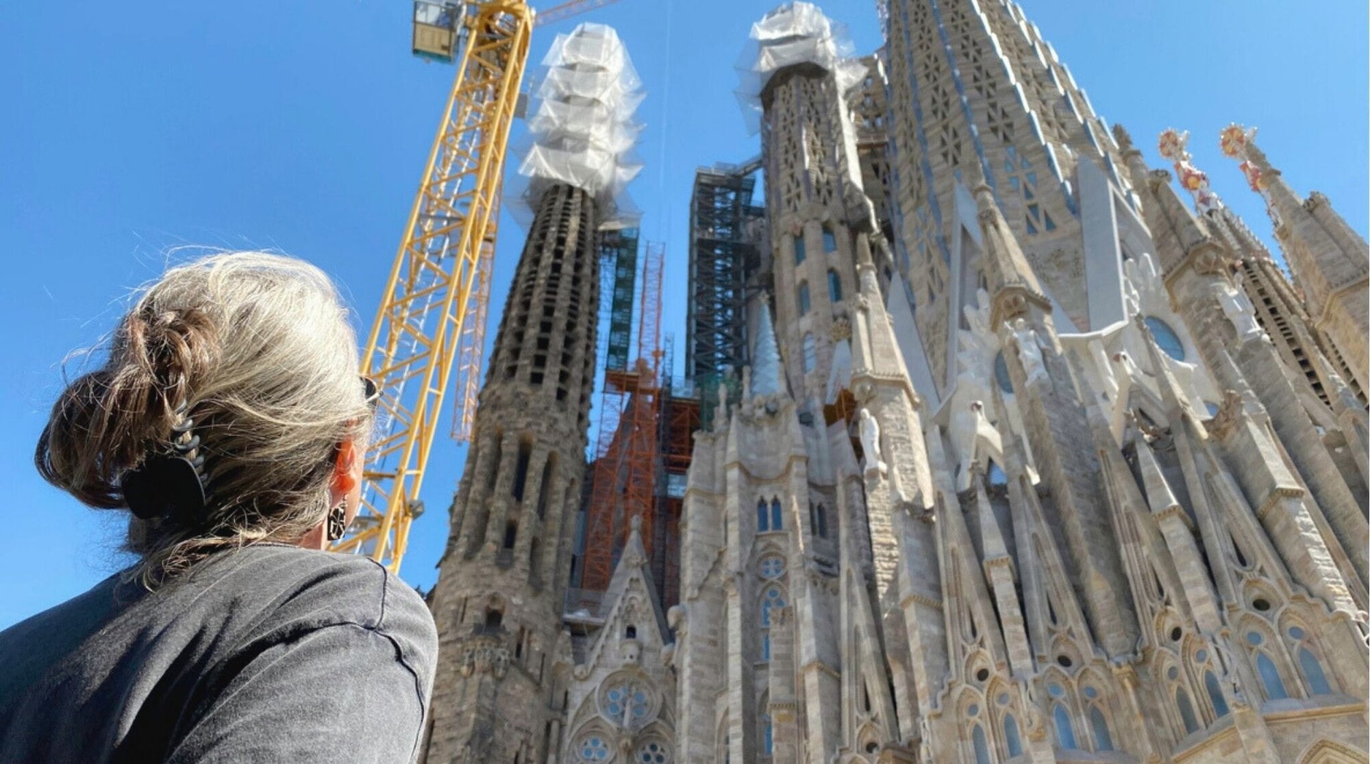 Viajera observando la Sagrada Familia de Gaudí en Barcelona durante el día.