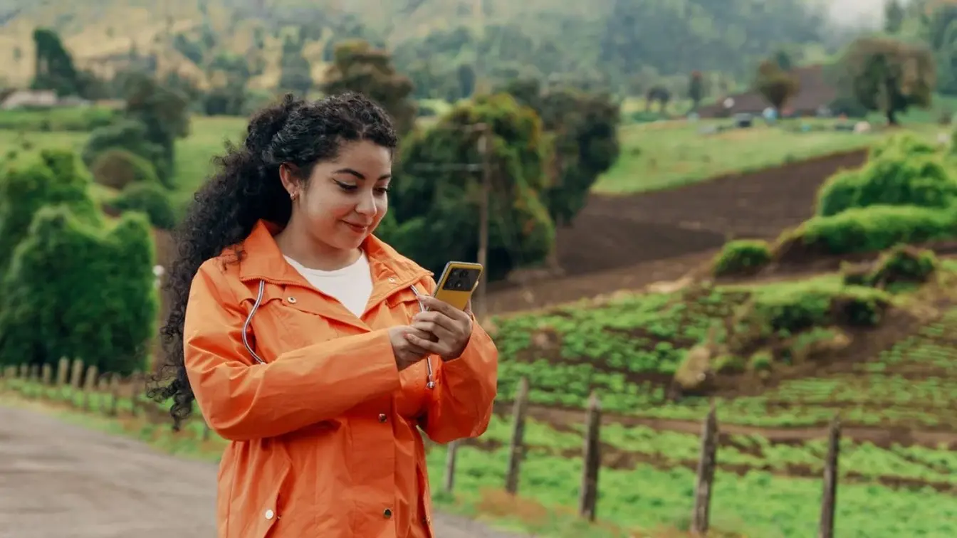 Eine Frau in einer grünen Landschaft in Costa Rica benutzt die beste eSIM, um online zu bleiben.